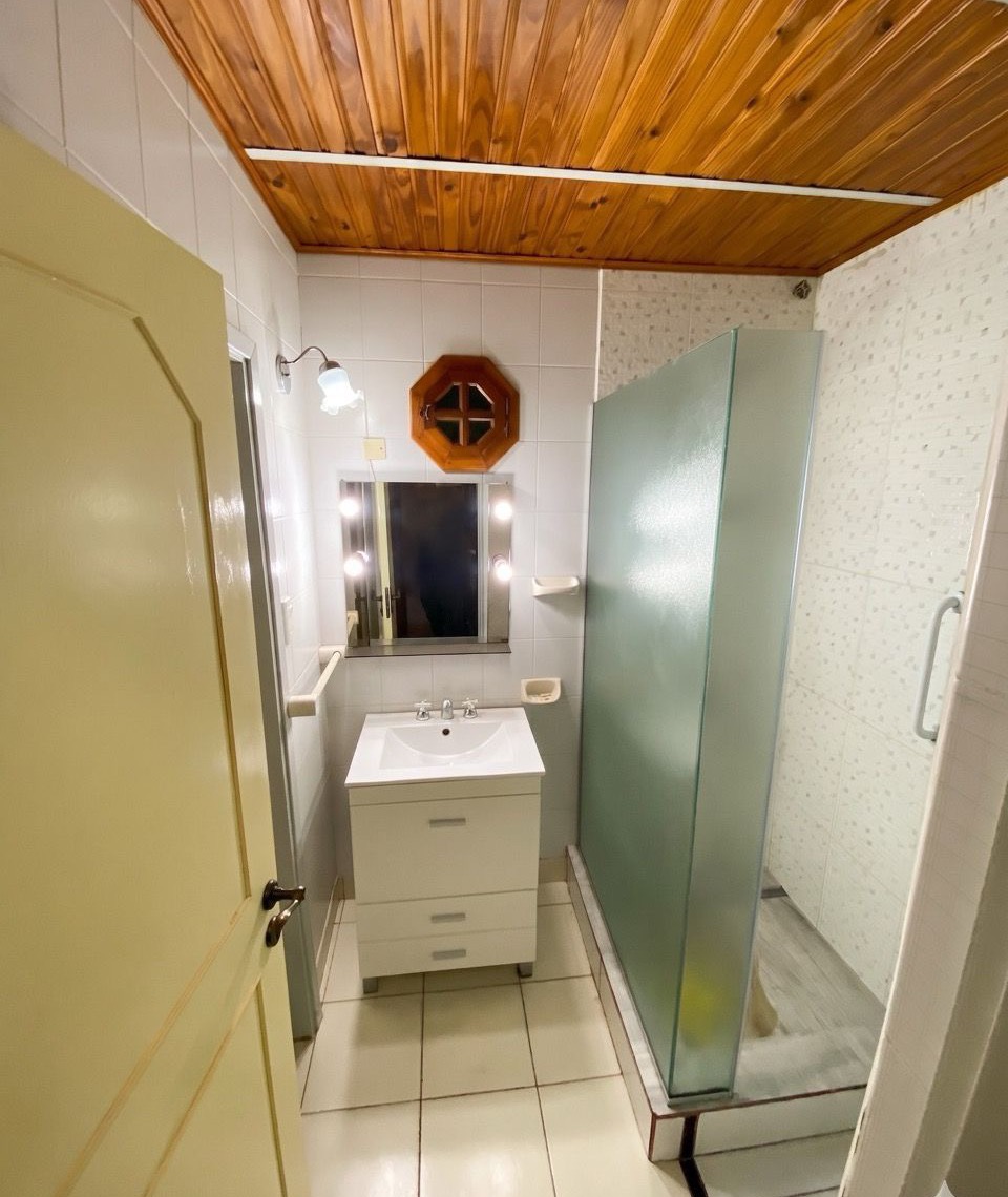 Baño con mampara de vidrio y mueble bajo mesada