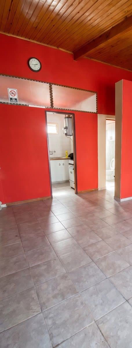 Interior del local con pared roja y la cocina al fondo